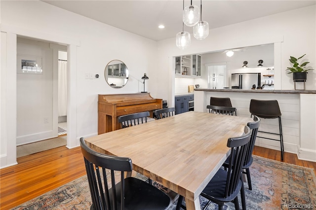 dining space featuring baseboards, recessed lighting, and wood finished floors