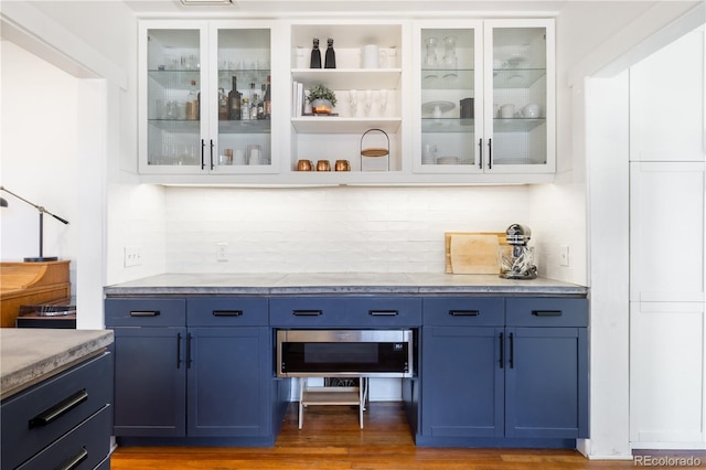 bar with a dry bar, light wood-style flooring, and tasteful backsplash