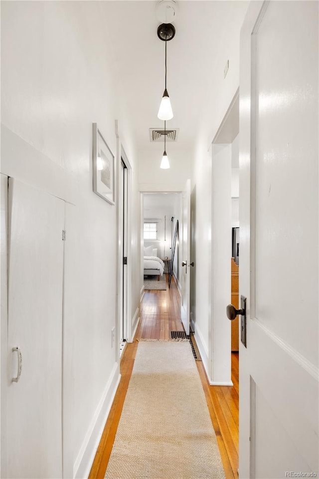 hallway with visible vents and light wood-style floors