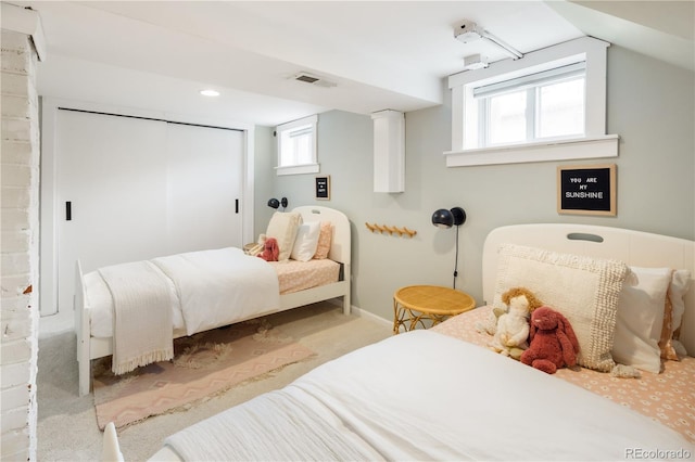 carpeted bedroom with visible vents, baseboards, a closet, and multiple windows