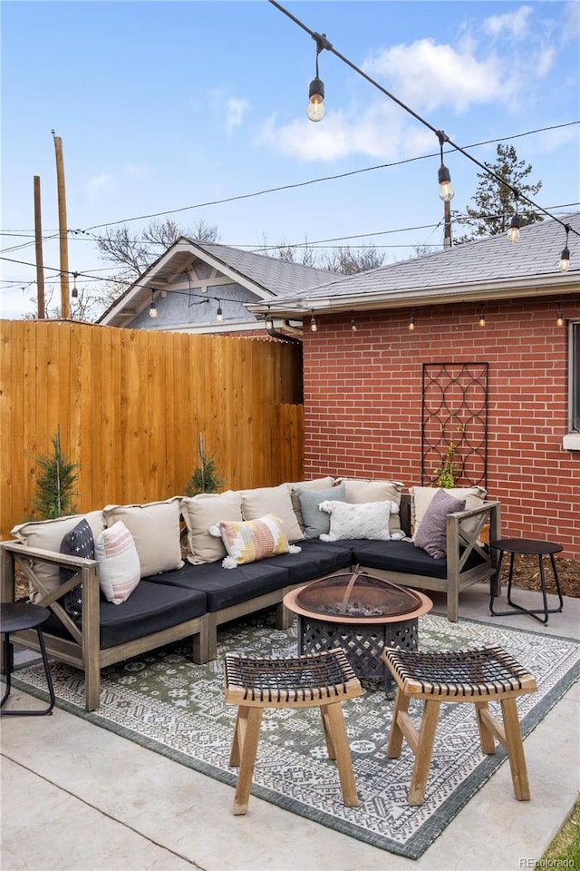 view of patio featuring an outdoor living space with a fire pit and fence
