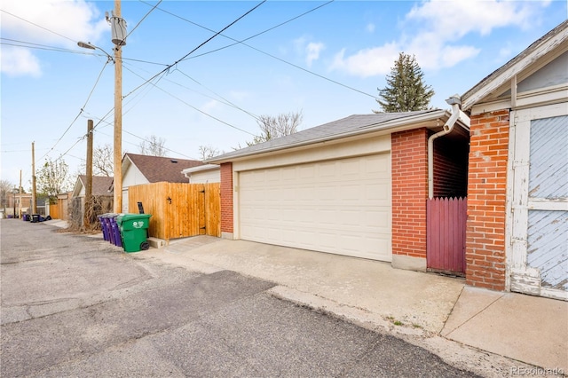 detached garage with fence and a gate