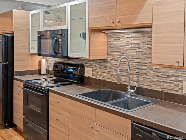 kitchen featuring tasteful backsplash, sink, and black appliances