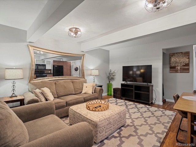 living room featuring hardwood / wood-style flooring, a chandelier, and beamed ceiling