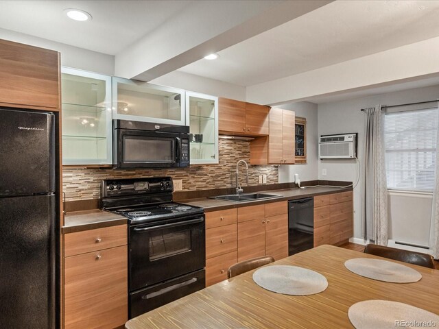 5873 S Prince St Unit 209B, Littleton, CO 80120 - kitchen with black appliances, an AC wall unit, a sink, and tasteful backsplash