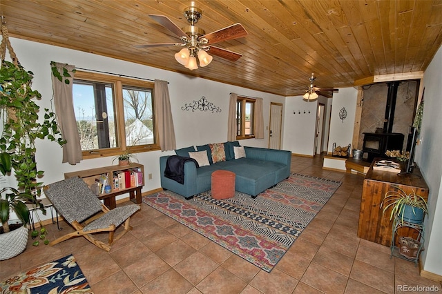 tiled living room with ceiling fan, a wood stove, and wood ceiling