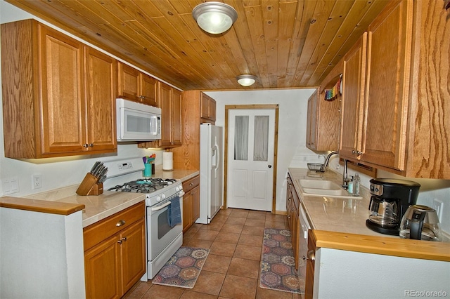 kitchen with tile patterned flooring, white appliances, sink, and wooden ceiling