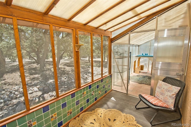 sunroom with a healthy amount of sunlight and vaulted ceiling