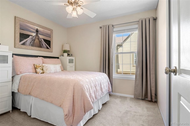 bedroom featuring light colored carpet, ceiling fan, a textured ceiling, and baseboards