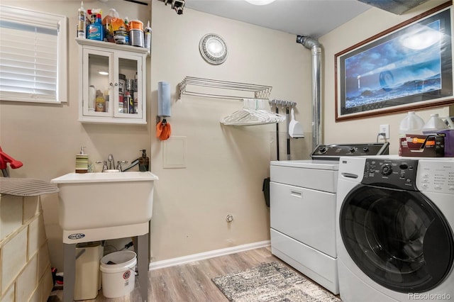 laundry area featuring laundry area, light wood-type flooring, and washing machine and dryer