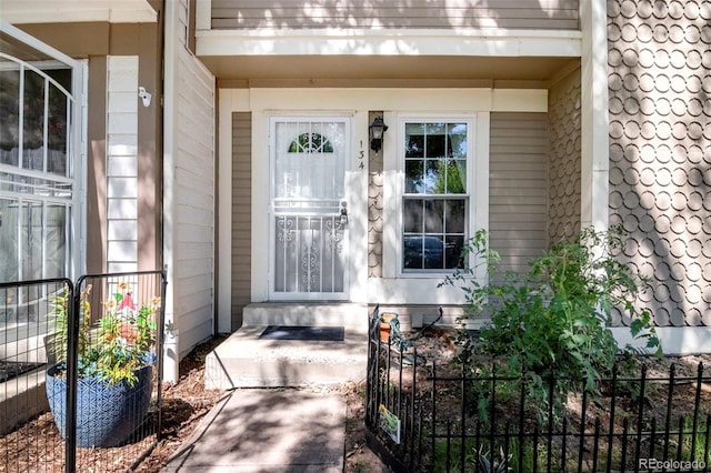 entrance to property featuring a tile roof and fence