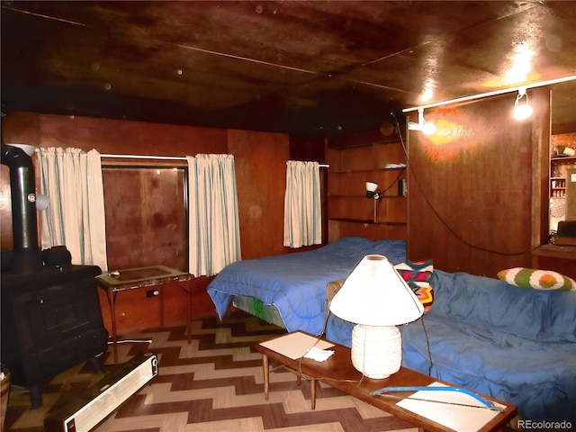 bedroom featuring a wood stove and parquet flooring