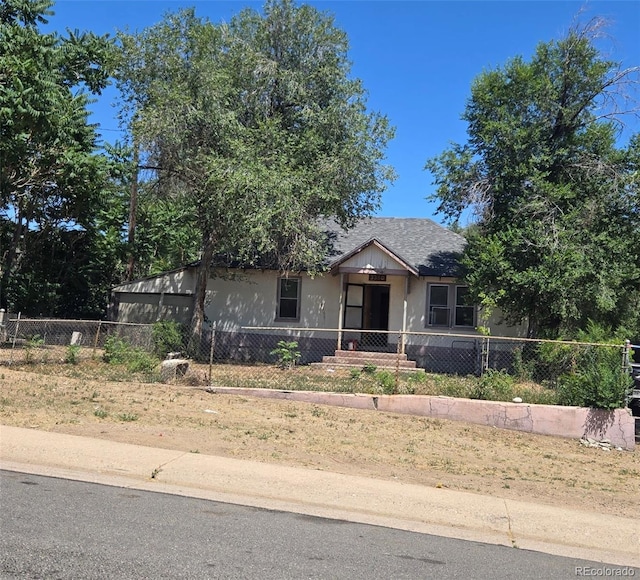 3350 S Eliot St, Englewood, CO 80110 - view of front facade with a fenced front yard and roof with shingles