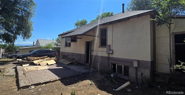 3350 S Eliot St, Englewood, CO 80110 - view of side of property with a patio area and a shingled roof