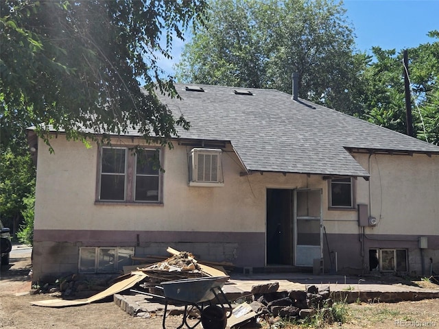 3350 S Eliot St, Englewood, CO 80110 - view of front of home with roof with shingles, an outdoor fire pit, and a patio area