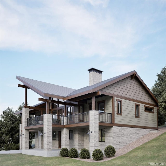 back of property featuring a balcony and a yard