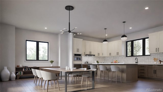 kitchen featuring white cabinetry, a breakfast bar area, hanging light fixtures, a kitchen island, and a notable chandelier