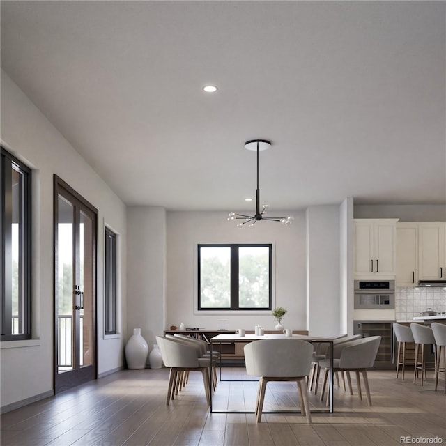 dining area with an inviting chandelier and hardwood / wood-style flooring