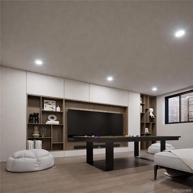 recreation room with light hardwood / wood-style floors and built in shelves