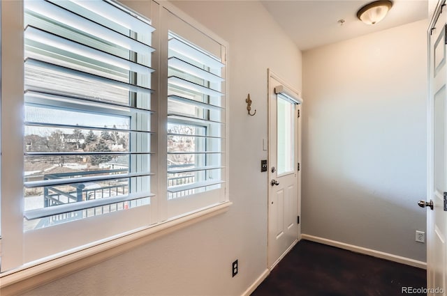 doorway to outside with baseboards