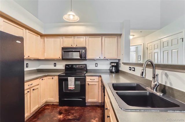 kitchen featuring dark countertops, decorative light fixtures, a sink, and black appliances