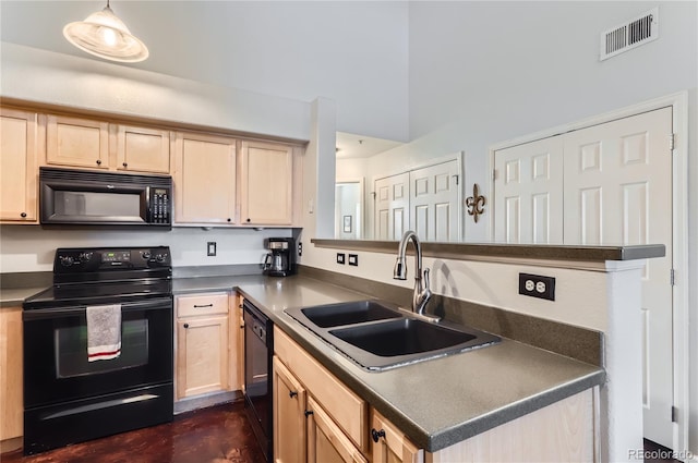 kitchen with decorative light fixtures, dark countertops, visible vents, a sink, and black appliances