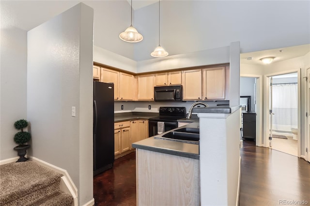 kitchen with dark countertops, a peninsula, light brown cabinetry, black appliances, and pendant lighting