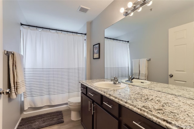 bathroom with shower / tub combo with curtain, visible vents, toilet, vanity, and wood finished floors