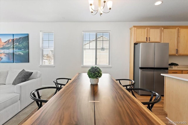 dining space with a notable chandelier and light wood-type flooring