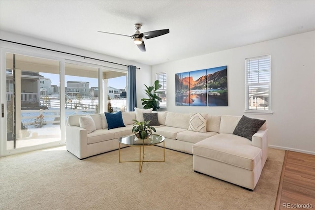 carpeted living room with ceiling fan