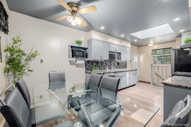9170 Aspen Dr, Thornton, CO 80229 - dining room with a skylight, a ceiling fan, light wood-type flooring, and recessed lighting