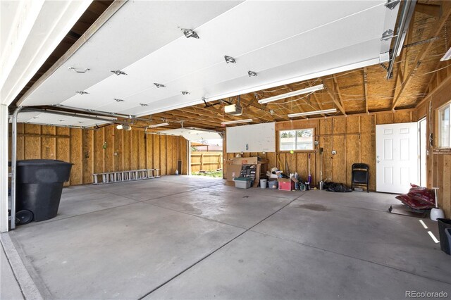 1400 S Knox Ct, Denver, CO 80219 - garage featuring a garage door opener and wooden walls