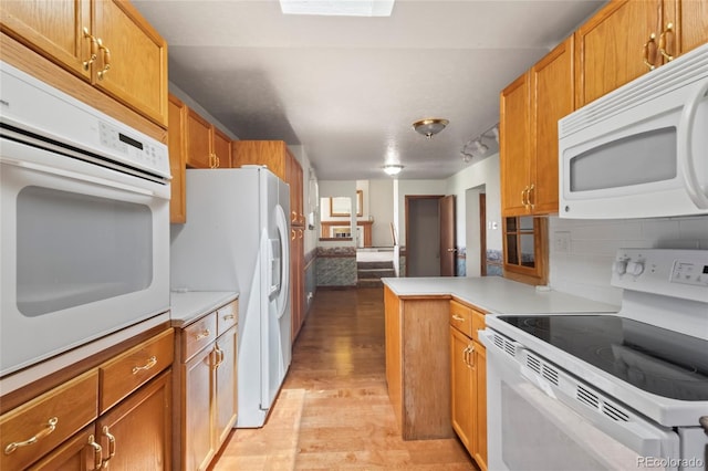 1400 S Knox Ct, Denver, CO 80219 - kitchen featuring white appliances, light wood finished floors, tasteful backsplash, light countertops, and brown cabinets