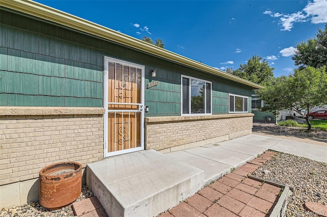 5556 Vaughn St, Denver, CO 80239 - doorway to property featuring brick siding