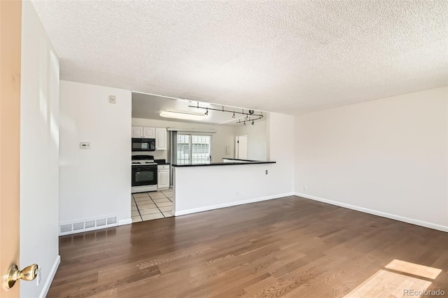 5556 Vaughn St, Denver, CO 80239 - unfurnished living room with wood finished floors and a textured ceiling