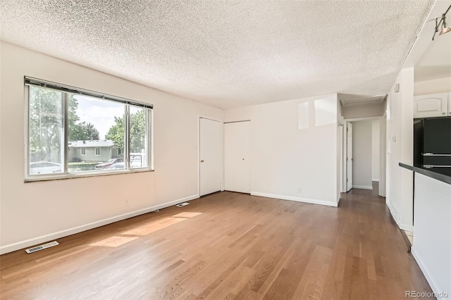 5556 Vaughn St, Denver, CO 80239 - unfurnished living room with a textured ceiling and wood finished floors