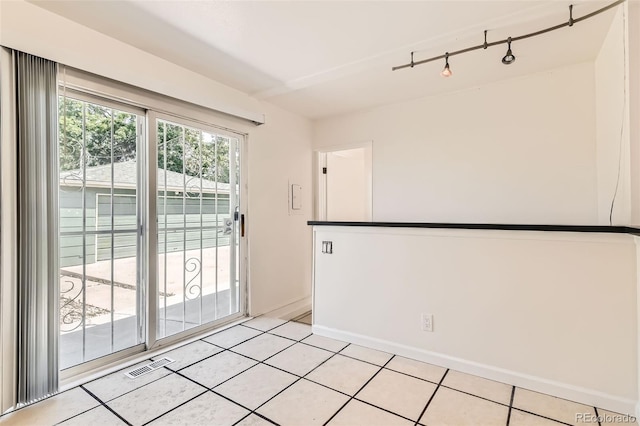 5556 Vaughn St, Denver, CO 80239 - spare room with rail lighting and light tile patterned floors