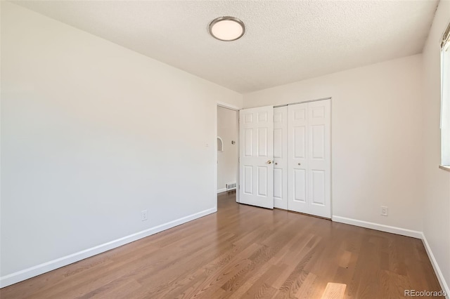 5556 Vaughn St, Denver, CO 80239 - unfurnished bedroom featuring wood finished floors, a closet, and a textured ceiling