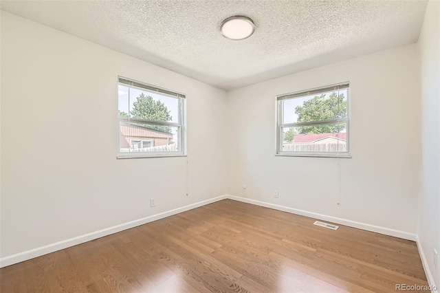 5556 Vaughn St, Denver, CO 80239 - spare room with healthy amount of natural light, wood finished floors, and a textured ceiling