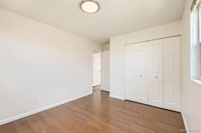 5556 Vaughn St, Denver, CO 80239 - unfurnished bedroom with wood finished floors, a textured ceiling, and a closet