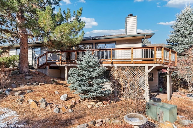 back of property with a deck and a chimney