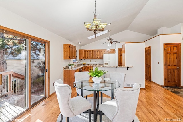 dining area featuring vaulted ceiling, ceiling fan with notable chandelier, visible vents, and light wood finished floors