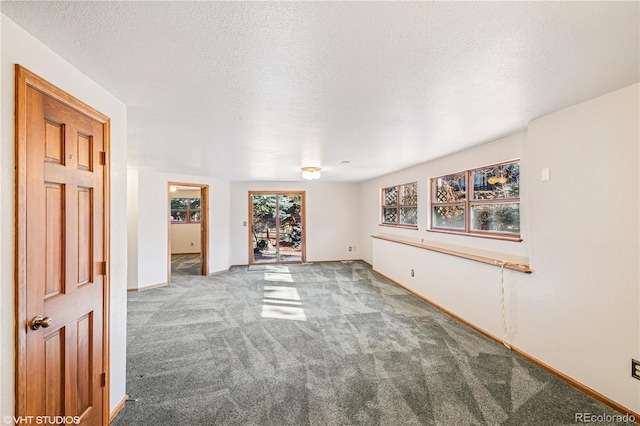 empty room with baseboards, carpet floors, and a textured ceiling