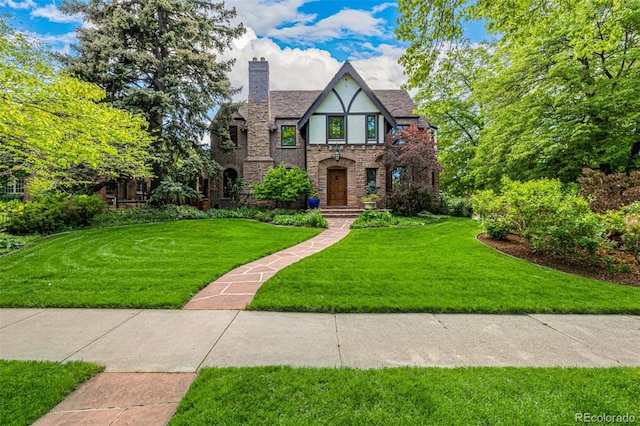 1795 N Monaco St Parkway, Denver, CO 80224 - tudor-style house with stone siding, a front yard, a chimney, and stucco siding