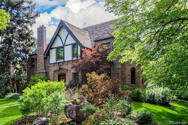 1795 N Monaco St Parkway, Denver, CO 80224 - english style home featuring a chimney, stone siding, a front lawn, and stucco siding