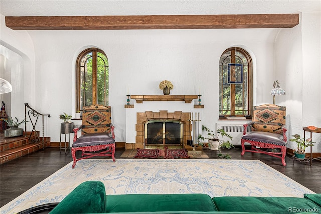 1795 N Monaco St Parkway, Denver, CO 80224 - living area featuring beam ceiling, wood finished floors, baseboards, radiator, and a fireplace with flush hearth