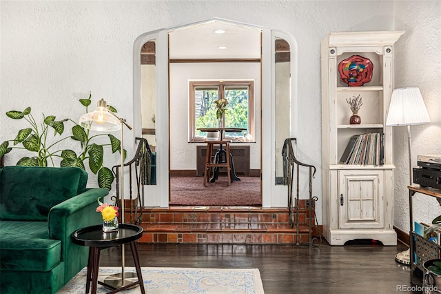 1795 N Monaco St Parkway, Denver, CO 80224 - sitting room featuring a textured wall, arched walkways, and wood finished floors