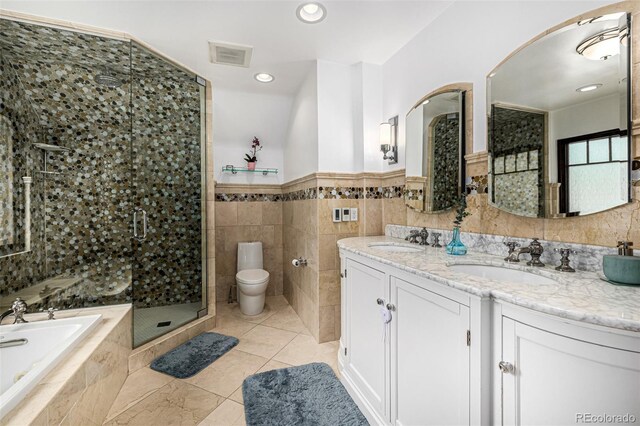 1795 N Monaco St Parkway, Denver, CO 80224 - bathroom with a bath, double vanity, a stall shower, tile walls, and toilet