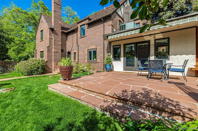 1795 N Monaco St Parkway, Denver, CO 80224 - rear view of property featuring a yard, brick siding, a patio area, and a chimney