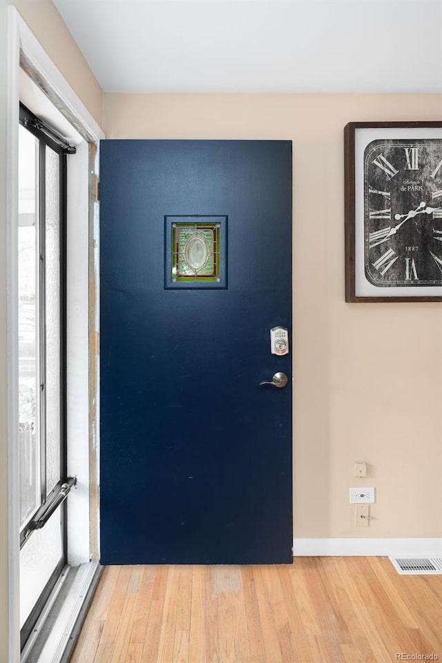 entrance foyer featuring wood finished floors, visible vents, and baseboards